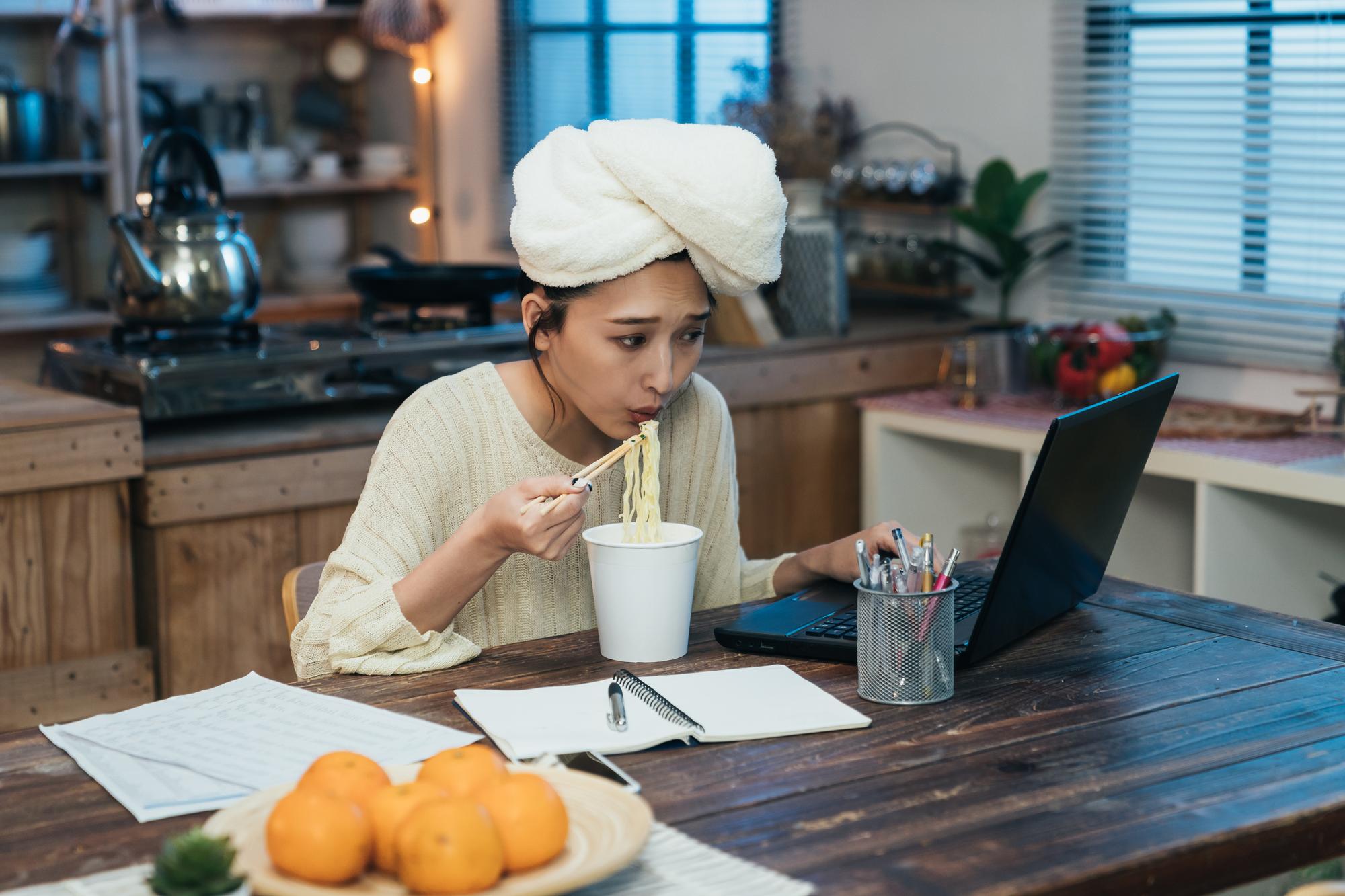 Studente che segue corso dal laptop nella cucina di casa